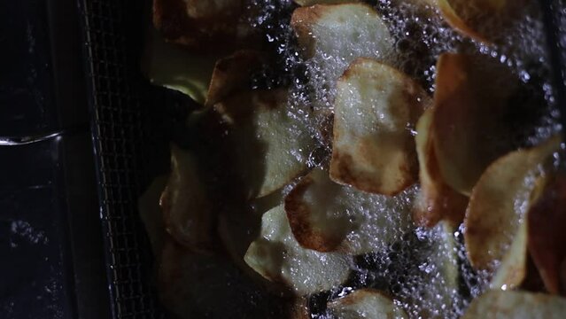 Slow mo close-up shot of potatos being removed from the oil.