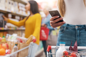 Woman using a smartphone at the supermarket