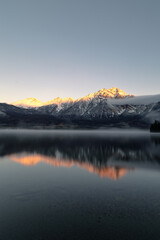 Scenic view of a tranquil lake surrounded by snowy mountains