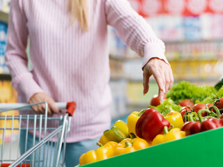 Woman buying fresh organic vegetables at the supermarket