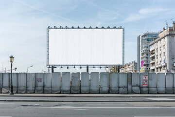 Urban street with a complex, multi-paneled blank billboard on a segmented concrete structure.