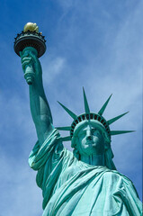 Fototapeta premium Eingescanntes Diapositiv einer historischen Farbaufnahme der Freiheitsstatue in New York in extremer Unteransicht bei sonnigem Wetter und leichter Bewölkung