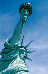 Fototapeta premium Eingescanntes Diapositiv einer historischen Farbaufnahme der Freiheitsstatue in New York in extremer Unteransicht bei sonnigem Wetter und leichter Bewölkung