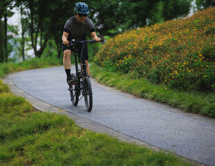 Woman riding folding bike in sunny park