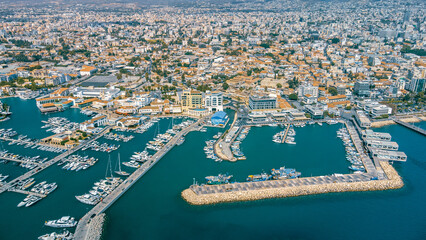 Obraz premium View of boats docked in a harbor with city buildings and sky in Limassol Marina, Cyprus