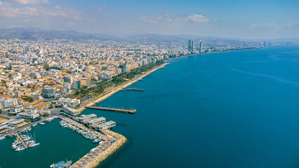 Fototapeta premium View of boats docked in a harbor with city buildings and sky in Limassol Marina, Cyprus