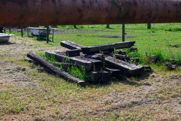 Pile of old used wooden train sleepers stacked in a horse pasture in Belgium