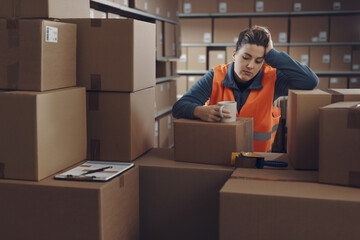 Tired warehouse employee having a break