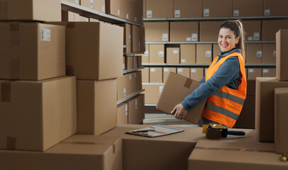 Portrait of a warehouse worker carrying a box