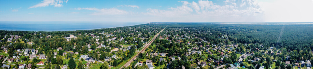 Expansive aerial view of Jurmala, Latvia, showcasing the Baltic Sea coastline, lush pine forests, and charming seaside town
