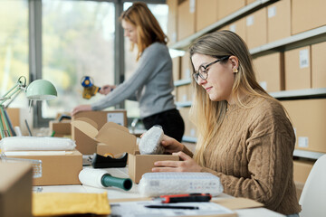 Woman putting goods in a delivery box