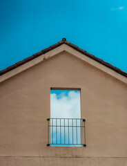 Vertical shot of the clouds and blue sky visible behind a balcony of a building