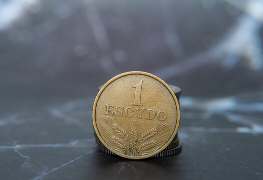 Portugese centavo coin stacked on a table in a neat pile