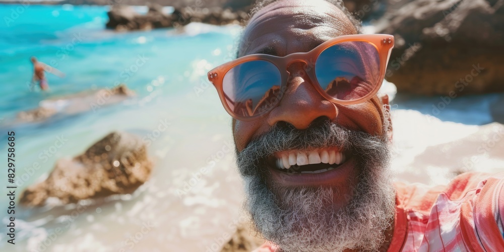 Poster a man with a beard and sunglasses is smiling at the camera while standing on a beach. the beach is r