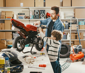 Young man and his son fixing a motorbike together