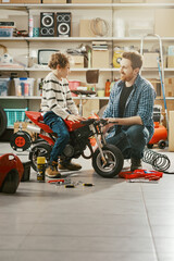 Happy kid riding a motorcycle and his father