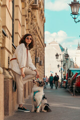 Obraz premium Young Caucasian pretty woman walking in city with purebred Aussie dog. Vertical orientation. Pet training