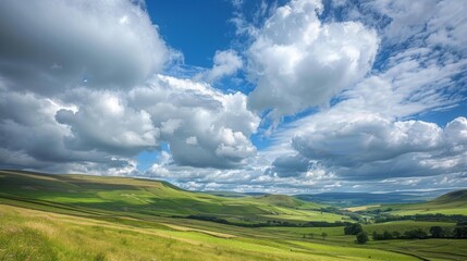 A picturesque countryside scene with rolling hills and valleys, framed by a sky filled with billowing cumulus clouds.