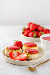 Vegan cheesecakes, syrniki, cheese pancakes with berries, jam, cashew and tofu. Sugar, lactose and gluten free. Vertical orientation.