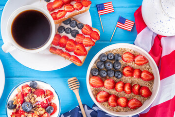USA patriotic breakfast or brunch with american flag decorated oatmeal, layered yogurt granola dessert, toast sandwiches with fresh berries, and coffee cup on kitchen garden table