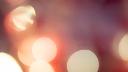 Golden and red bokeh lights create a soft, dreamy background