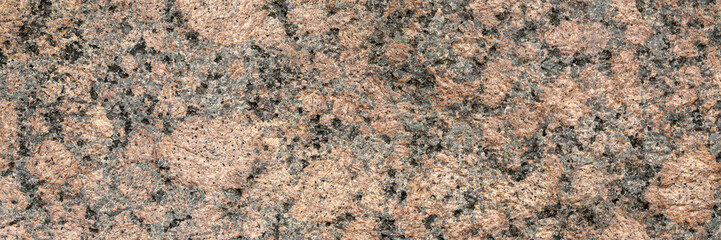 Naklejka premium Granite texture. Natural pink granite with a grainy pattern. Stone background. Solid rough surface of rock. Durable construction and decoration material. Close-up.