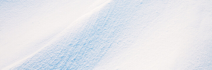 Beautiful winter background with snowy ground. Natural snow texture. Wind sculpted patterns on snow...