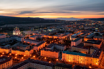 Obraz premium Aerial view of the city of Magadan. Beautiful night cityscape. Top view of the streets and buildings. In the distance is a sea bay. Early morning, dawn. Magadan, Magadan region, Russian Far East.