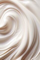 A swirl of white cream, which appears to be a type of lotion. The cream is spread out in a circular motion, creating a sense of movement and fluidity. Scene is calm and soothing
