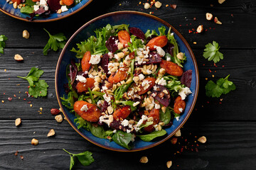 Warm baked carrots and beetroot salad with feta cheese and roasted hazelnuts