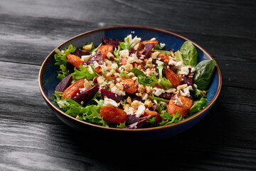 Warm baked carrots and beetroot salad with feta cheese and roasted hazelnuts