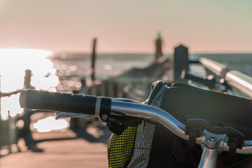 Bike parked on the seashore at sunset as a sustainable way of transport for summertime and...