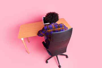 Top back view photo of worker guy sit desk table working netbook isolated pastel color background