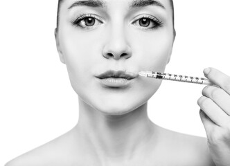 Obraz premium Young woman gets cosmetic injection in lips.
