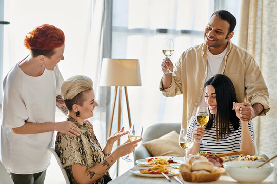 Diverse friends and a loving lesbian couple enjoy food and wine together. - Powered by Adobe