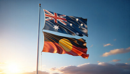 An Australian flag with an Aboriginal flag underneath, fluttering in the wind.