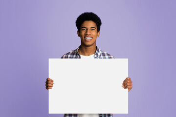 Happy guy showing blank placard with copy space for your text, pink background