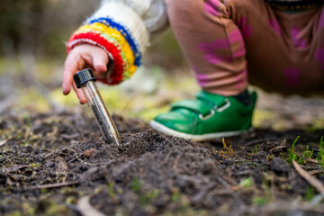 child taking a soil sample for a soil test in a field. family farm Testing carbon sequestration and plant health in Australia