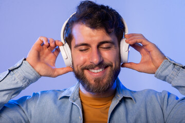 A man is shown wearing headphones and smiling directly at the camera. He appears happy and engaged,...