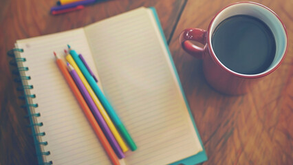 Cozy Workspace with Blank Notebook, Colorful Pencils, and a Hot Cup of Coffee