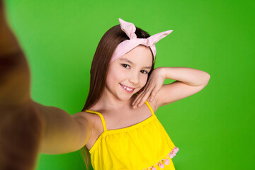 Photo of girlish pretty little lady dressed yellow outfit recording video vlog isolated green color...
