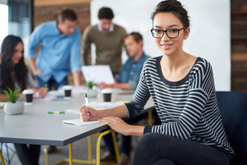 Woman, portrait and smile in office for career, meeting and workshop with business team. Modern workplace, female worker and planning for creative project, marketing and teamwork with notebook