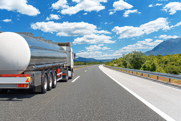 Fuel truck on a picturesque road. A silver tank truck transports fuel.