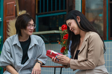 Asian couples playfully bond, sharing affectionate gazes, laughter, and intimate warmth outdoors.