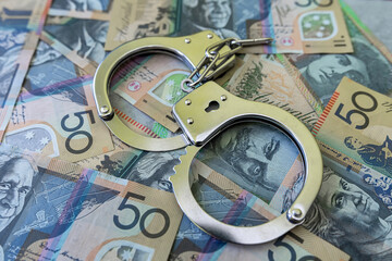 aud australian dollar with handcuff, finance crime concept