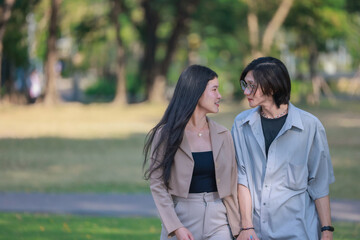 Fototapeta premium Asian couples playfully bond, sharing affectionate gazes, laughter, and intimate warmth outdoors.