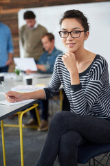 Portrait, woman and smile in office for creative project, meeting and workshop with team. Modern workplace, female worker and planning for career, content creator and designer with notebook by table