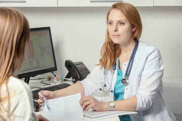Patient visiting his doctor at hospital. Doctor woman at work in hospital excited and happy of...