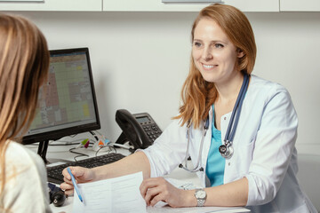 Patient visiting his doctor at hospital. Doctor woman at work in hospital excited and happy of...