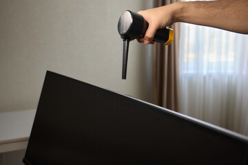 Someone is using a spray bottle to clean a television screen